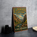 A vintage-style metal sign for Eldorado Canyon State Park in Colorado, featuring a scenic mountain landscape with a river and pine trees.