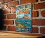 A vintage-style metal sign for Elephant Butte Lake State Park in New Mexico, featuring a scenic illustration of a lake, mountains, and a boat.