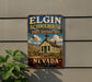 A vintage-style metal sign for Elgin Schoolhouse, a historic site in Nevada, featuring an illustration of a schoolhouse and mountains in the background.