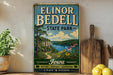 A vintage-style sign for Elinor Bedell State Park in Iowa, featuring a scenic landscape with a lake, mountains, and flowers.