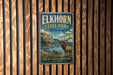 A vintage metal sign for Elkhorn State Park in Montana, featuring a scenic landscape with a large elk in the foreground.