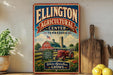 A vintage-style sign for the Ellington Agricultural Center in Tennessee, featuring a red tractor and a barn, is displayed on a shelf next to a wooden cutting board and some potted plants.