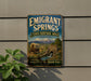 A vintage metal sign for Emigrant Springs, a state heritage area in Oregon, featuring a wagon train and a scenic landscape.