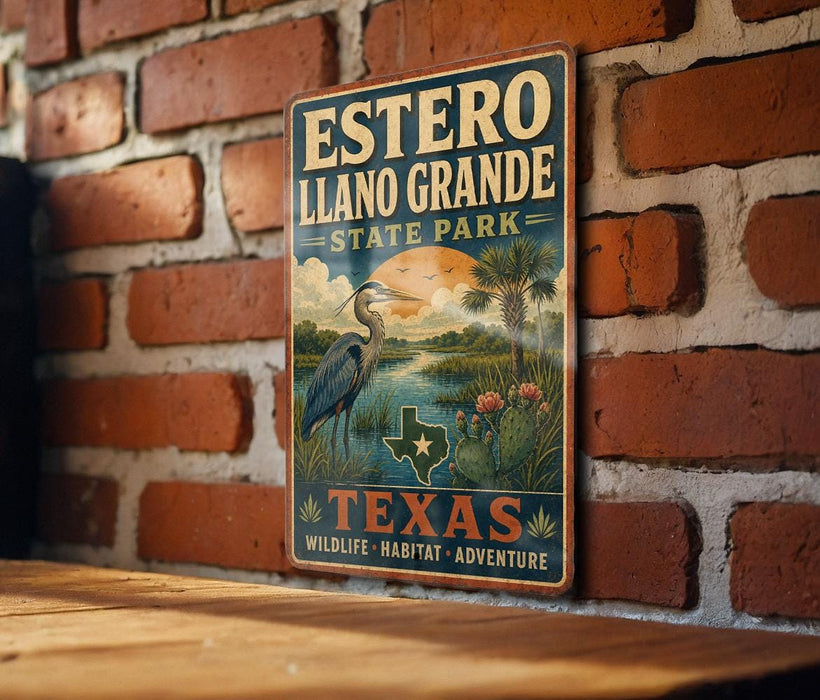 A vintage-style metal sign for Estero Llano Grande State Park in Texas, featuring a scenic illustration of a bird, palm trees, and a sunset landscape.