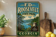 a vintage-style sign for F.D. Roosevelt State Park in Georgia, with a scenic landscape of trees, water, and mountains in the background.