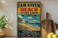a vintage-style sign for "Fair Haven Beach State Park New York", with a beach scene and lighthouse illustration.