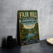 a vintage metal sign with a scenic landscape, including a lake and a bird, placed on a countertop next to some black camera lenses.