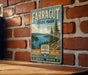 A vintage metal sign for Farragut State Park, featuring a scenic landscape with pine trees, a lake, and mountains.