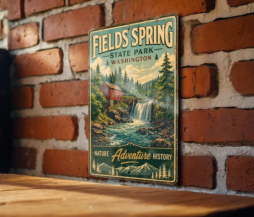 A vintage-style metal sign for Fields Spring State Park in Washington, featuring a scenic image of a waterfall and a cabin surrounded by nature.