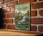 A vintage-style metal sign for Fields Spring State Park in Washington, featuring a scenic image of a waterfall and a cabin surrounded by nature.