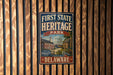 a vintage-style metal sign for Delaware Heritage Park, mounted on a wooden wall.