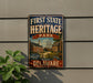 a vintage-style metal sign for First State Heritage Park in Delaware, with a colorful illustration of a historic building and ship on the sign.