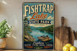 A vintage-style sign for Fish Trap Lake State Park in Kentucky, featuring a scenic image of a lake surrounded by mountains and a boat on the water.
