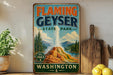 A vintage-style sign for Flaming Geyser State Park in Washington, featuring a scenic illustration of the geyser and surrounding landscape.