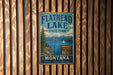 A vintage metal sign for Flathead Lake State Park, featuring a scenic illustration of the lake and mountains.