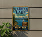 A vintage-style metal sign for Flathead Lake State Park, featuring a scenic landscape with mountains, a lake, and a sailboat.