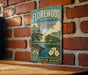 A vintage-style metal sign for "Florewood State Park, Mississippi" is displayed on a brick wall, featuring a scenic illustration of a lake, trees, and a cabin.