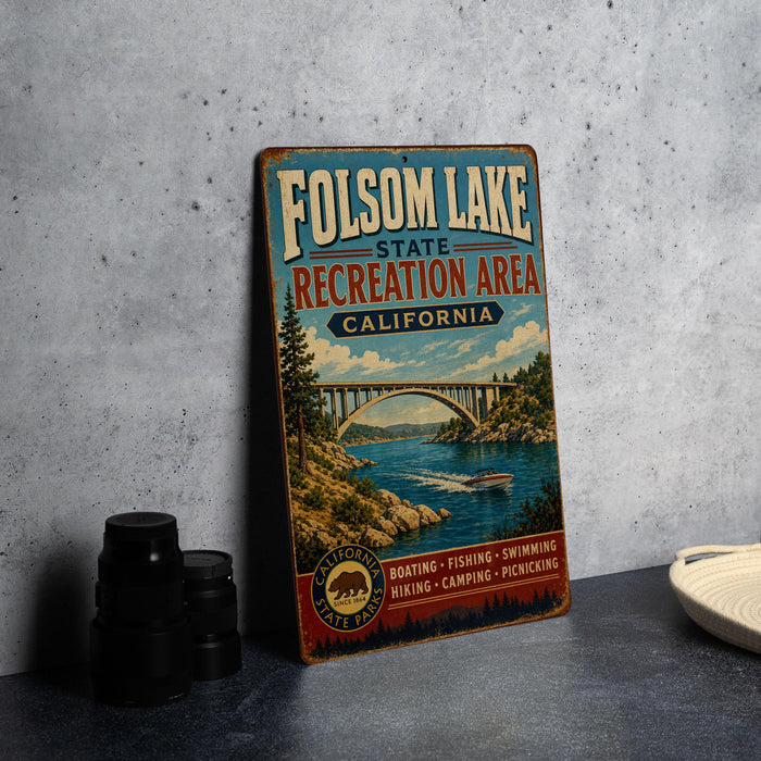 A vintage metal sign for Folsom Lake State Recreation Area in California, featuring a scenic illustration of the lake and a bridge.