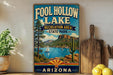 a vintage-style sign for Foolhole Lake, a recreation area in Arizona State Park, with a scenic landscape of mountains, a lake, and a sailboat.