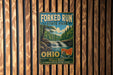 A vintage metal sign for Forked Run State Park in Ohio, featuring a scenic landscape with a waterfall and pine trees.