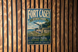 A vintage metal sign for Fort Casey State Park in Washington, featuring a scenic image of a cannon on a hill overlooking the ocean.