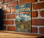 A vintage-style metal sign for the Fort Davidson State Historic Site in Missouri, featuring an illustration of a cannon and a wooden fence, mounted on a brick wall.