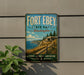 A vintage-style metal sign for Fort Ebey State Park in Washington, featuring a scenic landscape with a path leading to a building.