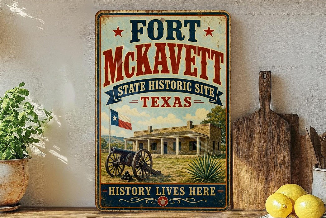 A vintage-style metal sign for Fort McKeett, Texas, featuring a cannon and a historic building, is displayed on a shelf next to a wooden cutting board and some lemons.