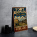 A vintage-style metal sign for Fort Robinson State Park in Nebraska, featuring an illustration of the state park and a prominent American flag.