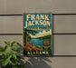 A vintage-style sign for Frank Jackson State Park in Alabama, featuring a scenic landscape with a lake and mountains.