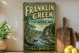 A vintage Franklin Creek State Natural Area sign is displayed on a shelf, surrounded by kitchen utensils and a potted plant.