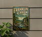 A vintage Franklin Creek State Natural Area sign is displayed on a wall, featuring a scenic illustration of the creek surrounded by lush greenery.
