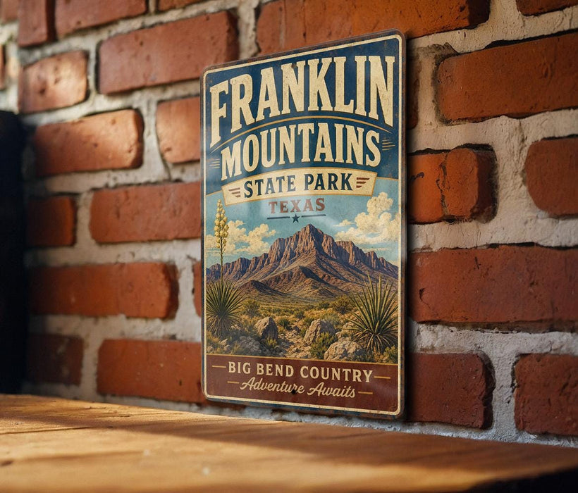 A vintage Franklin Mountains State Park sign is displayed on a brick wall, with a wooden table below it.