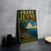 A vintage-style metal sign for Franz Jevne State Park in Minnesota, featuring a scenic landscape with pine trees, a lake, and mountains.