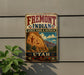 A vintage metal sign for Fremont Indian State Park & Museum, featuring an illustration of a Native American landscape with mountains and a rock formation.