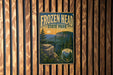 A vintage-style sign for Frozen Head State Park, featuring a scenic mountain landscape with pine trees and a sunset in the background.