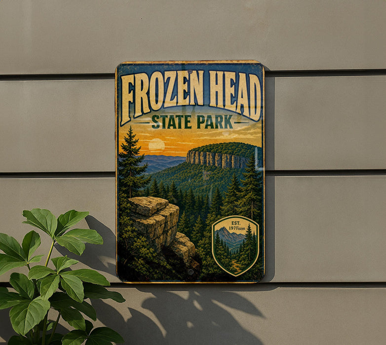 A vintage-style sign for Frozen Head State Park, featuring a scenic mountain landscape with pine trees and rocky cliffs.