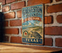 A vintage metal sign for Galveston Island State Park in Texas, featuring a turtle illustration and the text "Galveston Island State Park, Texas".