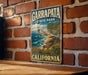 A vintage-style sign for Garrapata State Park in California, featuring a scenic coastal landscape with mountains, cliffs, and the ocean.