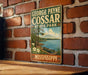 A vintage-style metal sign for George Payne Cossar State Park in Mississippi, featuring a scenic illustration of a lake, trees, and a canoe.