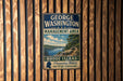 A vintage metal sign for the George Washington Management Area in Rhode Island, featuring a scenic landscape with a river and mountains.