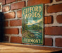 A vintage-style metal sign for Gifford Woods State Park in Vermont, featuring a scenic illustration of a river and forest landscape.