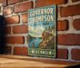 A vintage-style sign for Governor Thompson State Park in Wisconsin, featuring a scenic landscape with a lake and mountains.