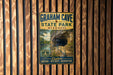 A vintage metal sign for Graham Cave State Park in Missouri, featuring a scenic image of the cave and the park's name.