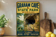 A vintage-style metal sign for Graham Cave State Park in Missouri, featuring a scenic image of the cave entrance surrounded by lush greenery.