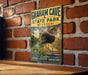 A vintage metal sign for Graham Cave State Park in Missouri, featuring a scenic image of the cave and a trail leading to the entrance.