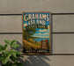 A vintage-style sign for Grahams Island State Park in North Dakota, featuring a scenic landscape with a lake and trees.