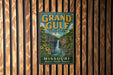 A vintage metal sign for Grand Gulf State Park in Missouri, featuring a waterfall and lush greenery, is displayed on a wooden wall.