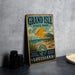 A vintage-style metal sign for Grand Isle State Park in Louisiana, featuring a beach scene with a palm tree and a bird.