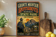 A vintage-style metal sign for the Granite Mountain Hotshots Memorial State Park in Arizona, featuring a firefighter standing in front of a mountain landscape.